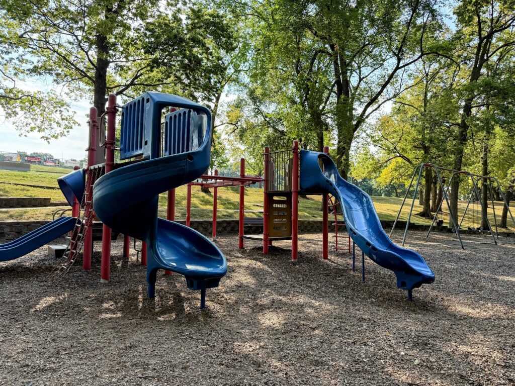 Classic playground with slides, swings, and plenty of shade.