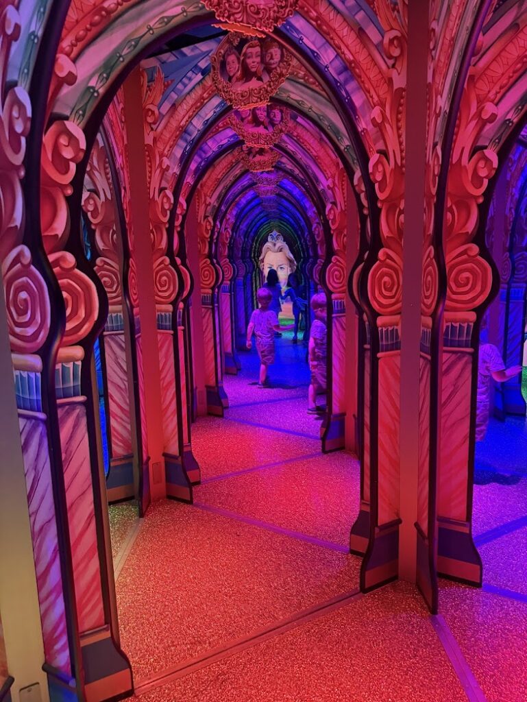 Bright, colorful mirrored hallway inside the Castle of Chaos Mirror Maze attraction in Branson, Missouri.