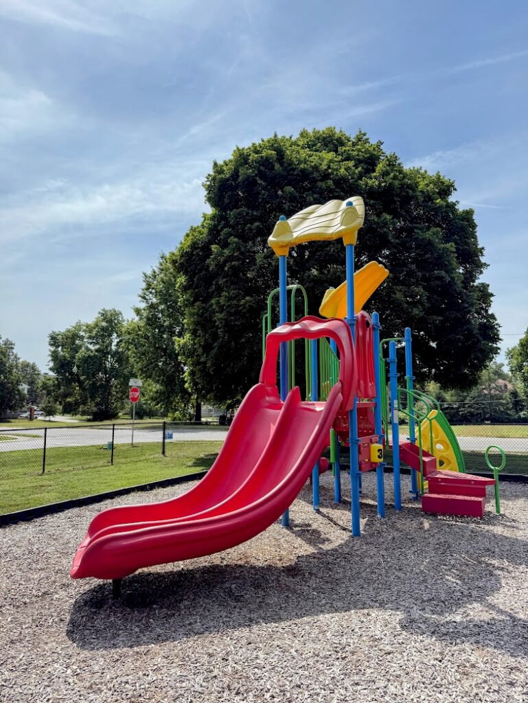 Bright red double slide and climbing structure for kids.