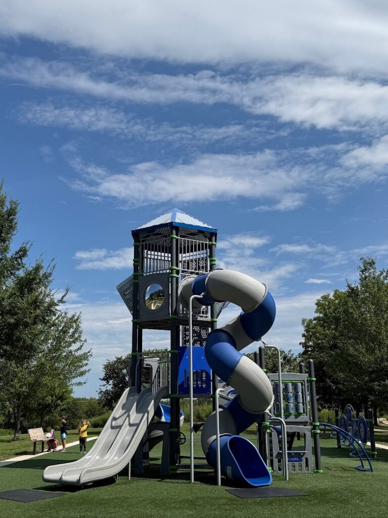 Multiple slides and twisty tube slide under a blue sky.