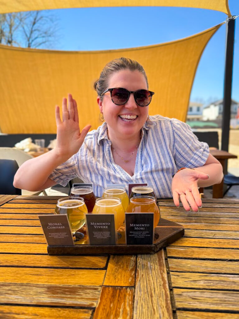 Woman enjoying a gluten free friendly beer flight on outdoor patio in Bentonville Arkansas brewery