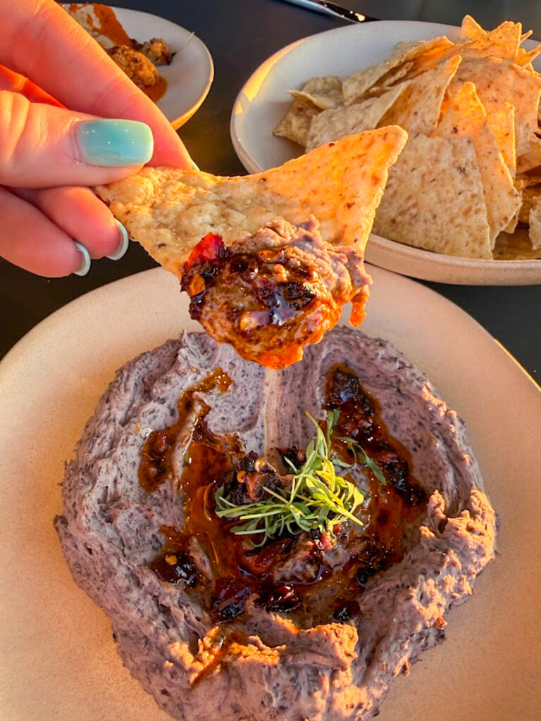 Gluten free chips dipping into hummus appetizer at Bentonville restaurant