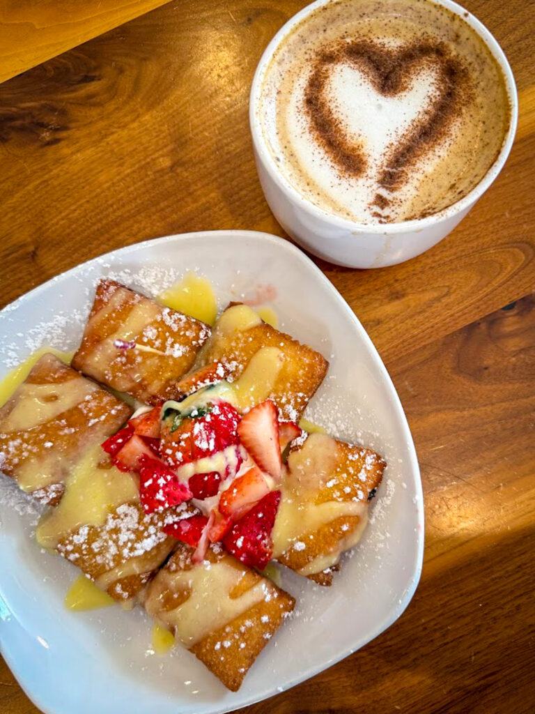 Gluten free beignets with strawberries and cream alongside latte at The Buttered Biscuit in Bentonville 