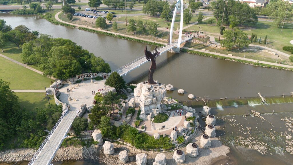 Drone view of the Keeper of the Plains monument and surrounding riverwalk where the Arkansas and Little Arkansas rivers meet in Wichita, Kansas. It's a great place to go to in Wichita with kids. 
