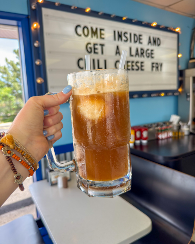 A frosty root beer float topped with vanilla ice cream sits in a classic diner-style mug, making a perfect family treat.